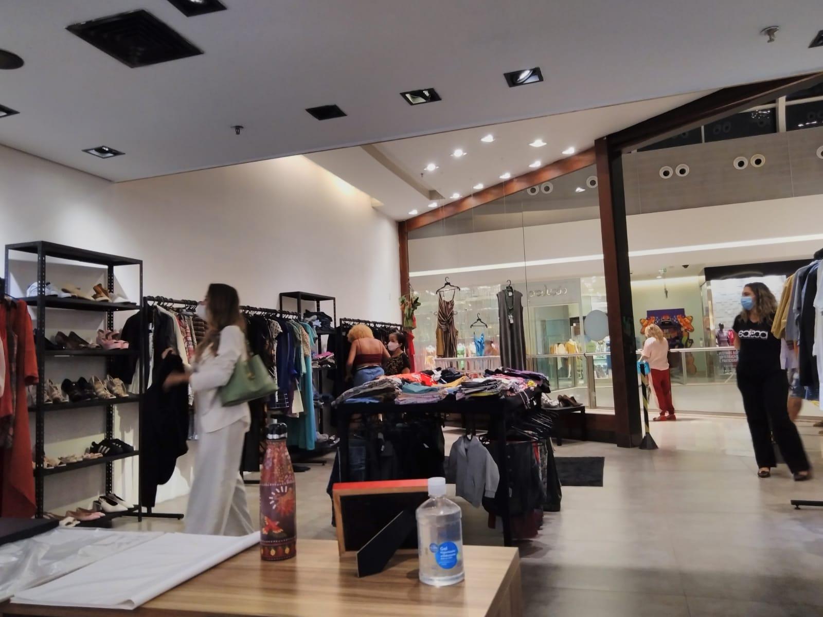 Consumidoras e voluntárias observando roupas do bazar