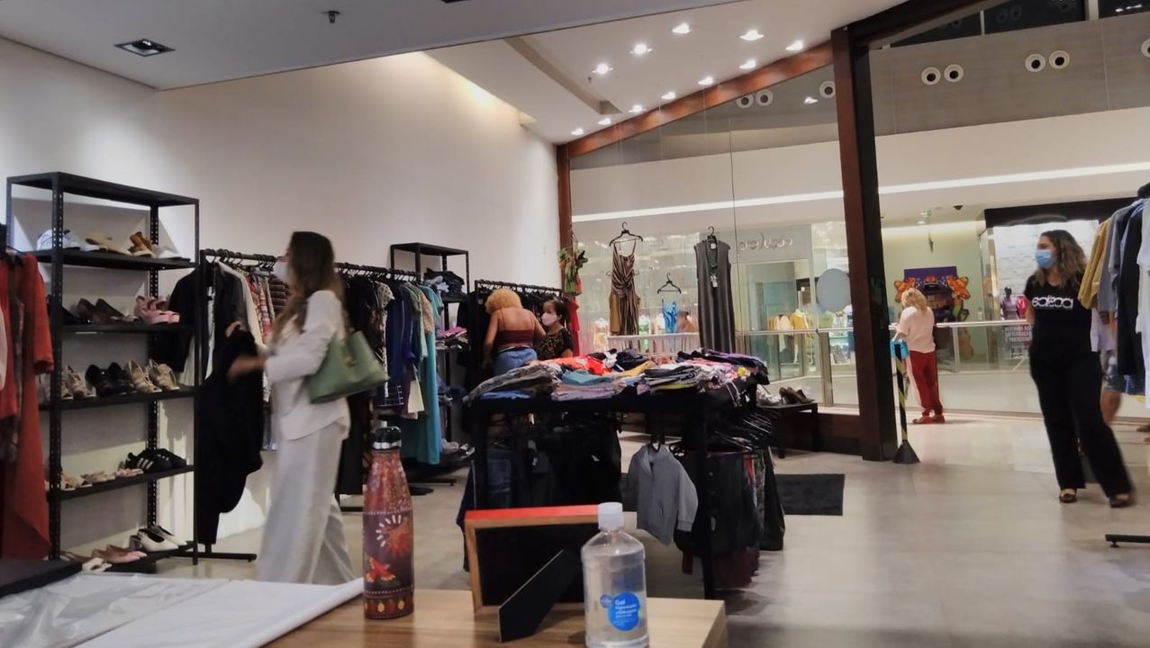 Consumidoras e voluntárias observando roupas do bazar