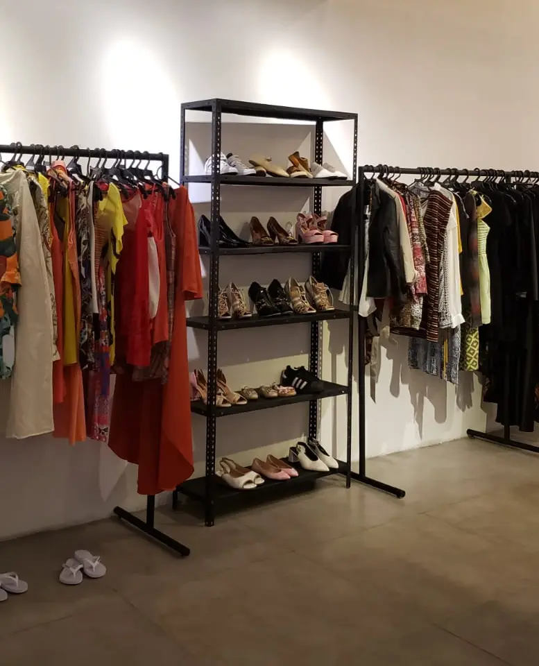 Imagem de araras e sapatos nas prateleiras do bazar