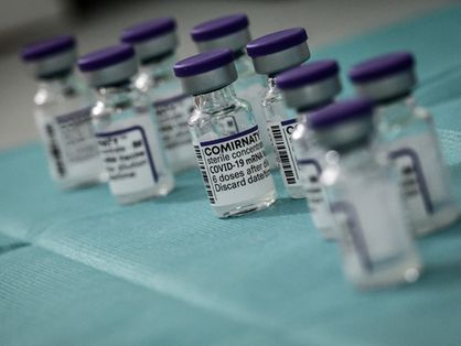 Frascos de vacina contra a Covid-19 da Pfizer sobre um fundo azul claro