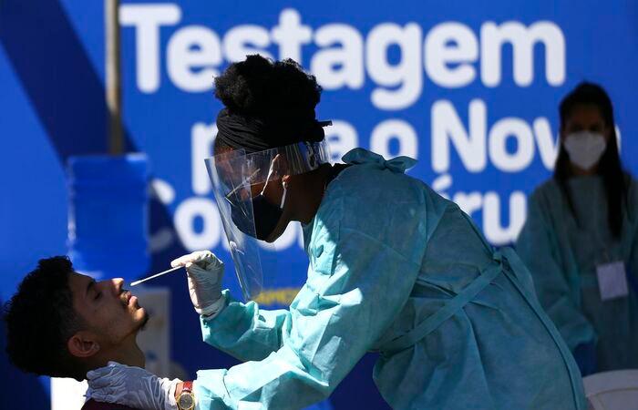 Profissional da saúde fazendo teste RT-PCR em um homem