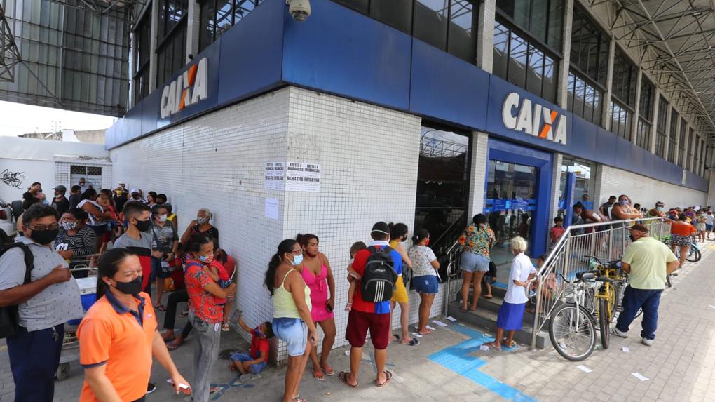 Pessoas aguardam em fila do lado de fora de agência da Caixa em Fortaleza no primeiro dia de pagamento do Auxílio Brasil de dezembro