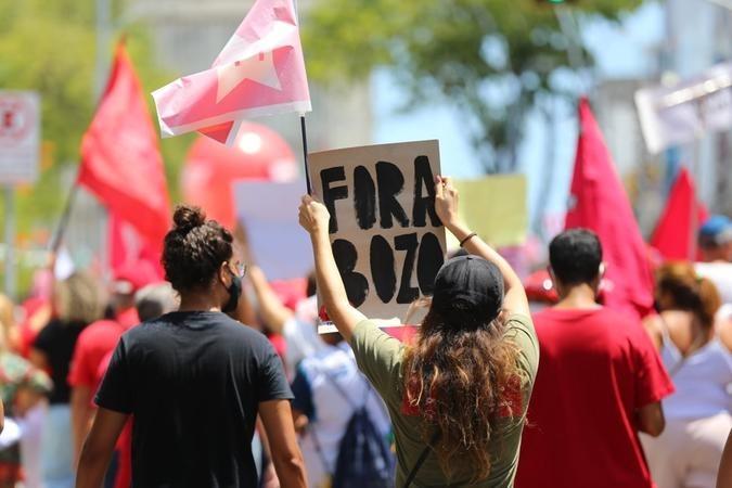 Manifestantes contrários ao governo Bolsonaro em ato em Fortaleza. Eles seguram um cartaz 