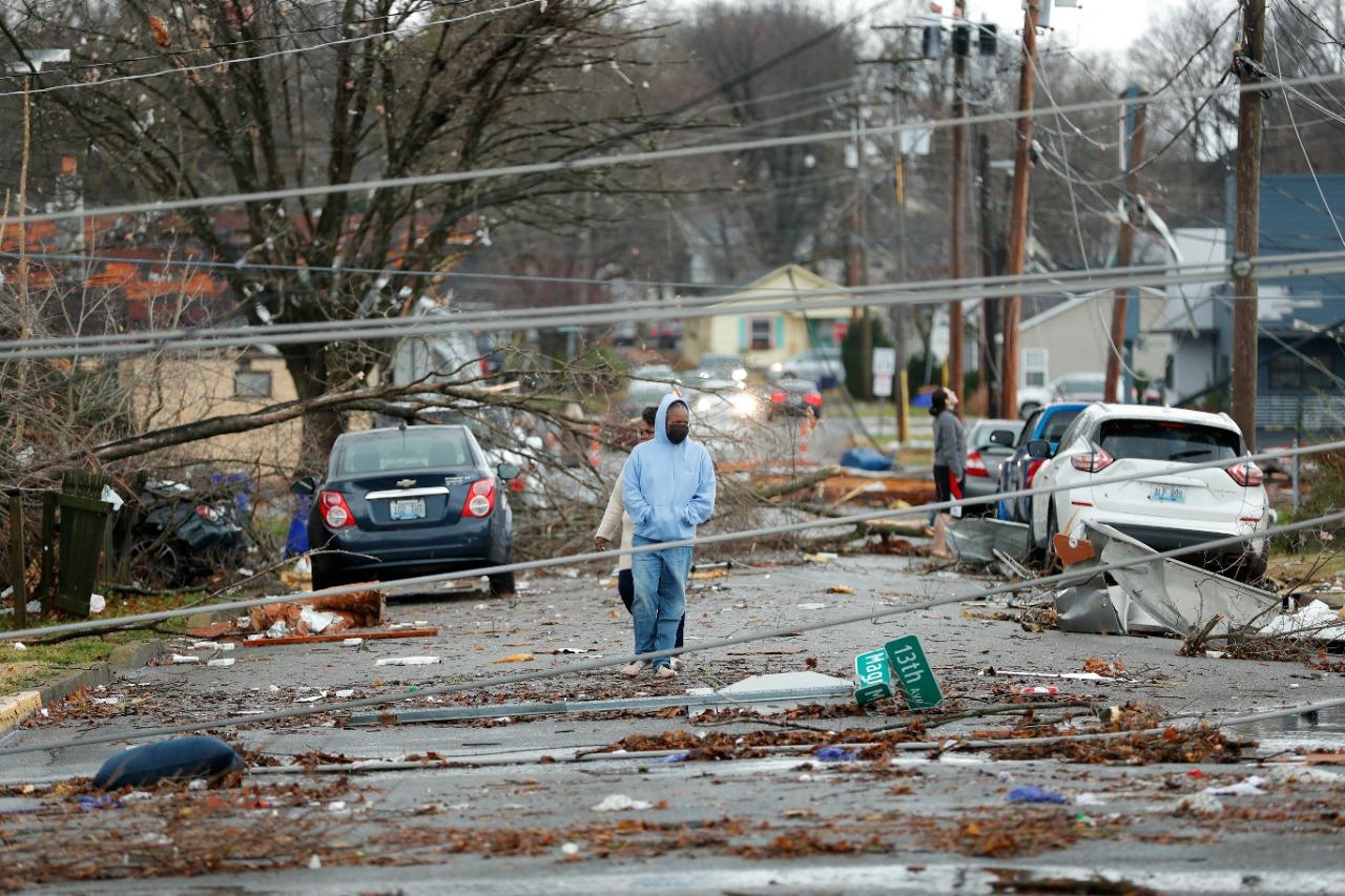 pessoas andando entre destruição deixada por tornado nos estados unidos