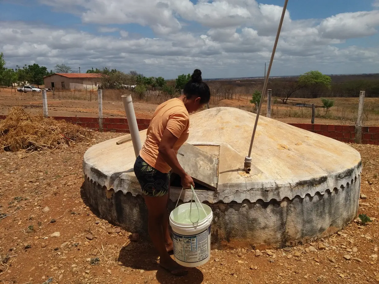 Mulher tira água em cisterna no Interior do Ceará