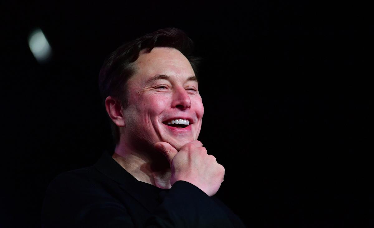 Musk sorri e coloca a mão no queixo