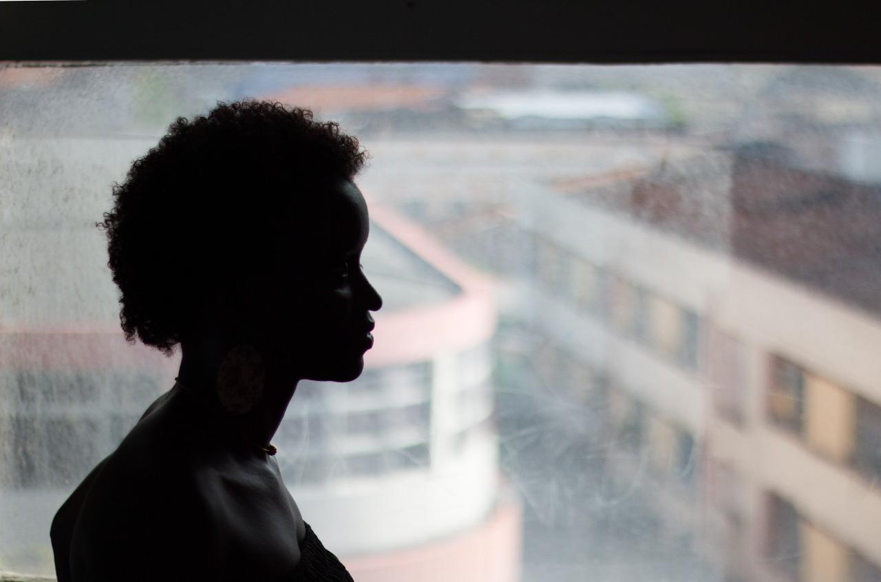 Silhueta de mulher negra com prédios ao fundo