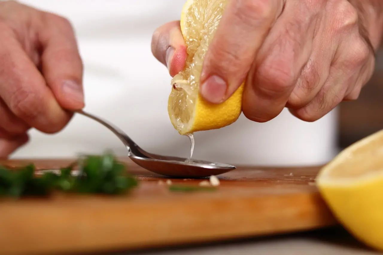 Pessoa espreme o limão na cozinha