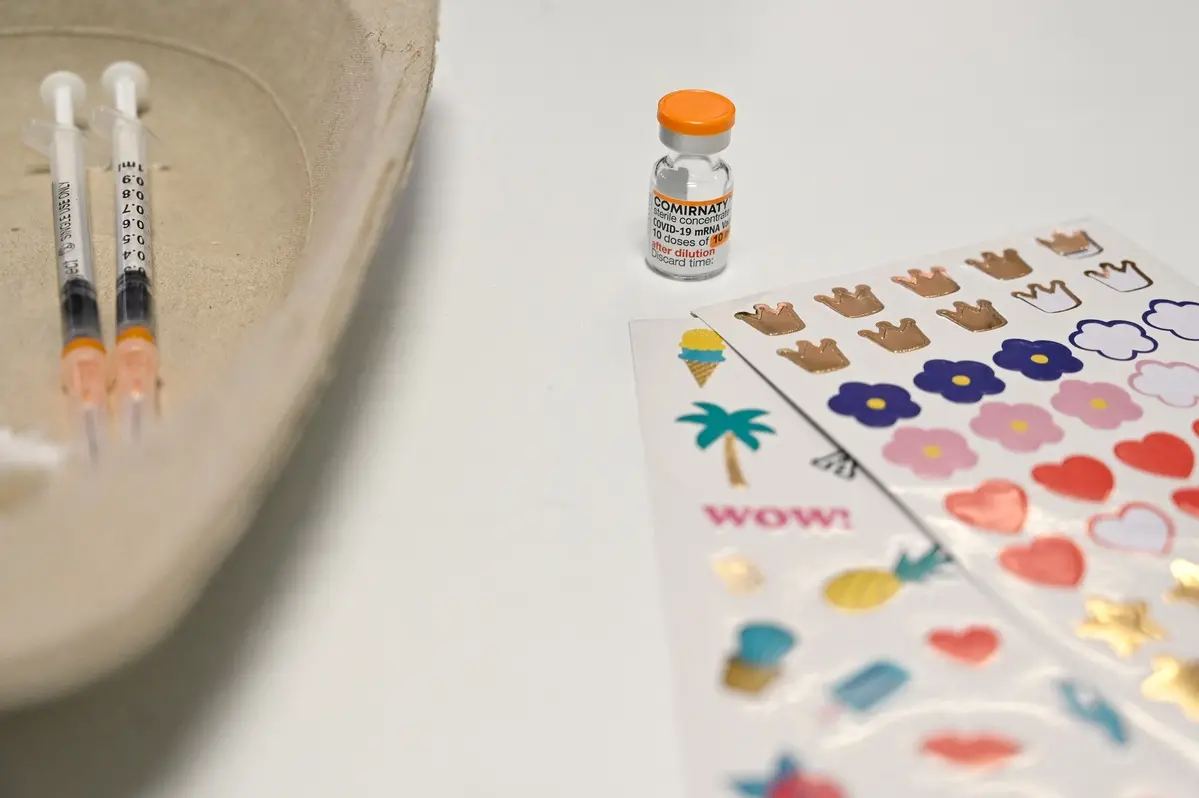 Vacina ao lado de adesivos para crianças