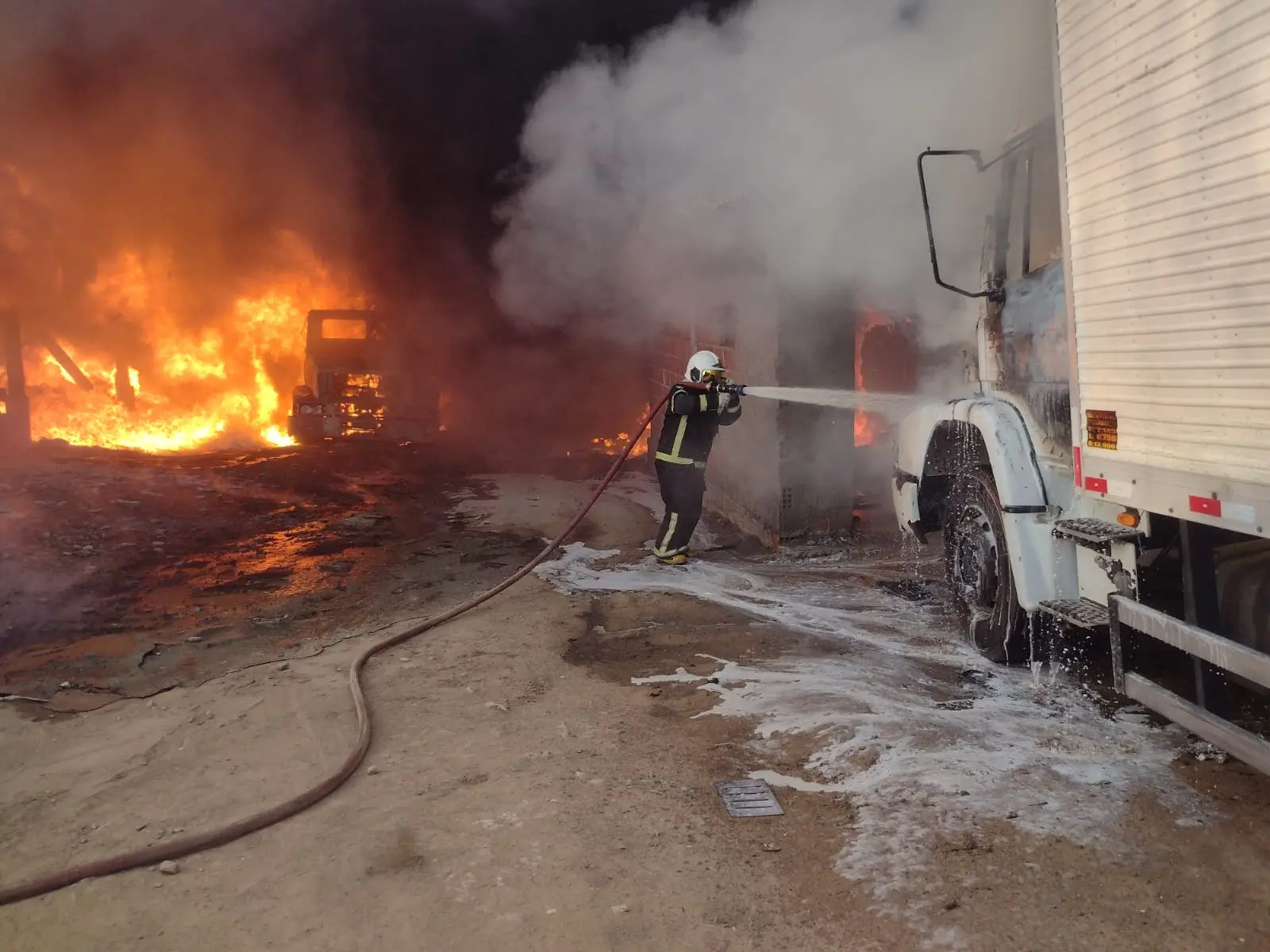 Momento em que um bombeiro utiliza a mangueira para combater o incêndio