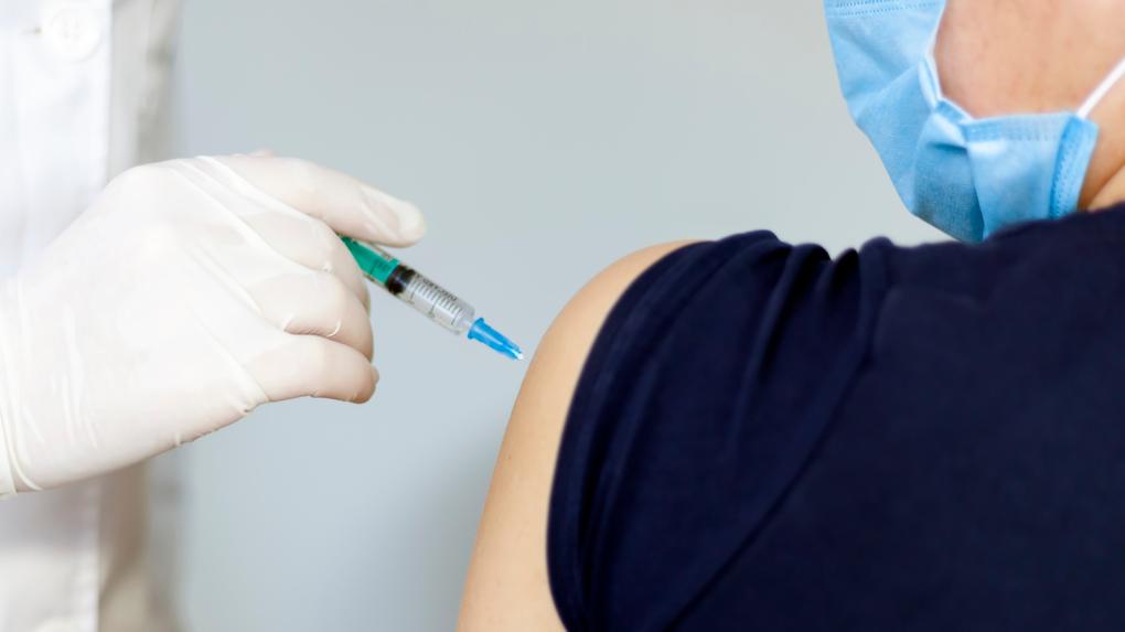 mão de um profissional da saúde aplicando injeção no ombro de paciente