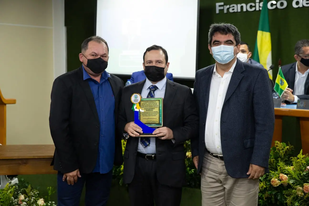 Igor Queiroz com o título de cidadão honorário cascavelense, acompanhado do vereador Gladson Bezerra (à esquerda) e do prefeito de Cascavel, Tiago Ribeiro (à direita)