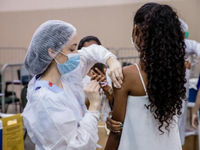 Profissional de saúde aplica vacina contra a Covid-19 em uma adolescente