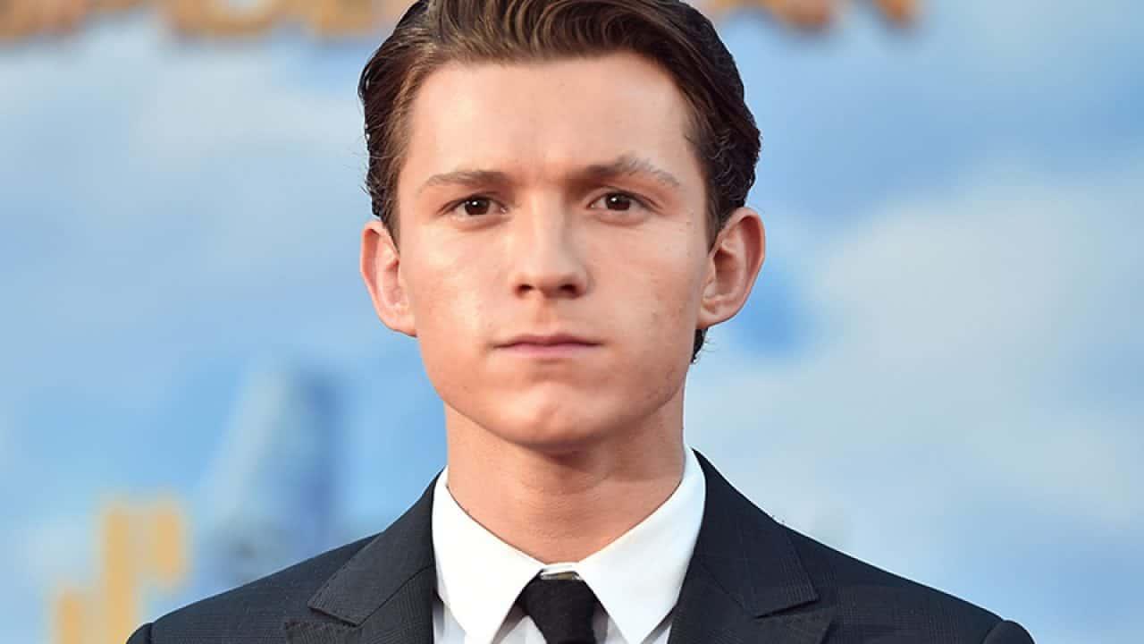 Tom Holland de terno e gravata olhando sério para a foto