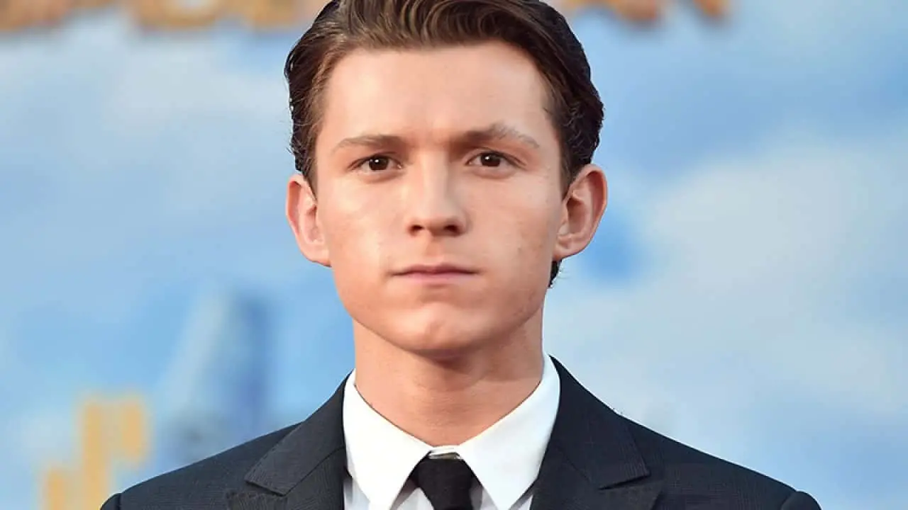 Tom Holland de terno e gravata olhando sério para a foto