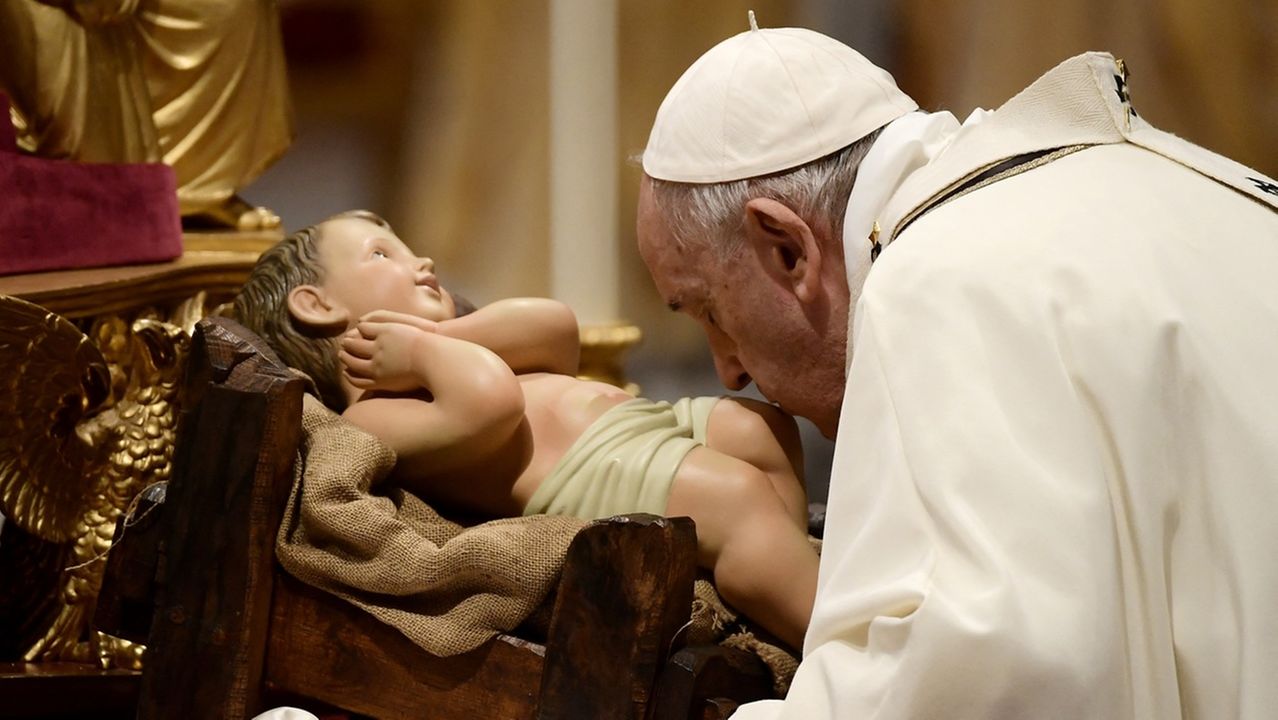 Papa beija os pés de uma imagem do Menino Jesus