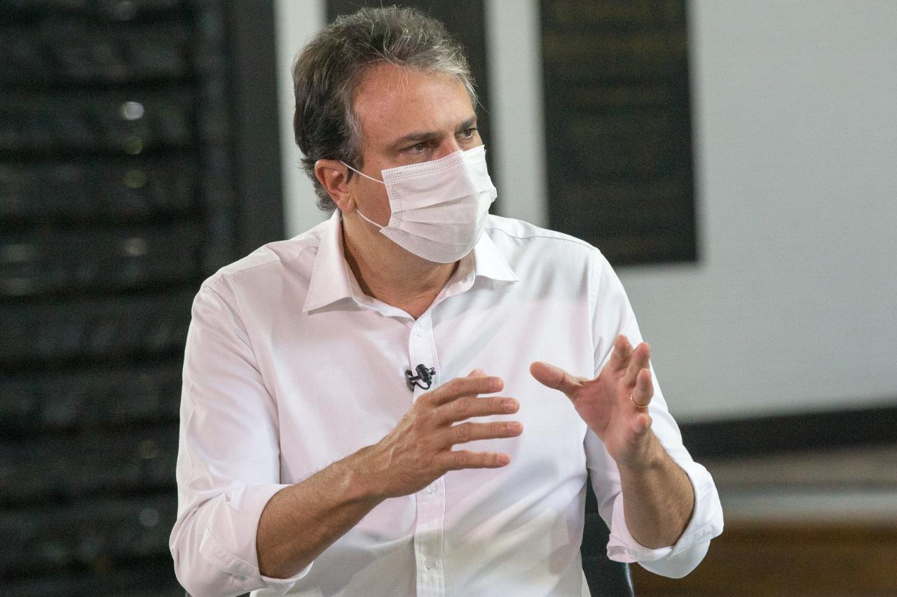 Governador do Ceará, Camilo Santana, com blusa branca e máscara de proteção facial durante entrevista