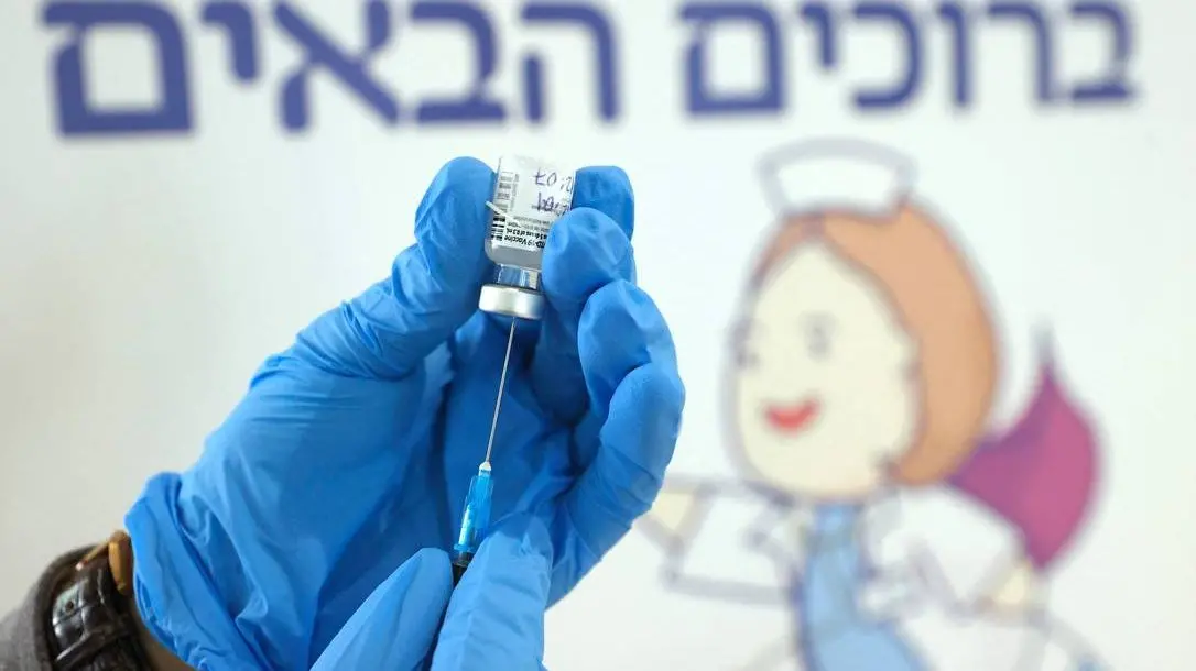 Profissional segura seringa e ampola de vacina anticovid