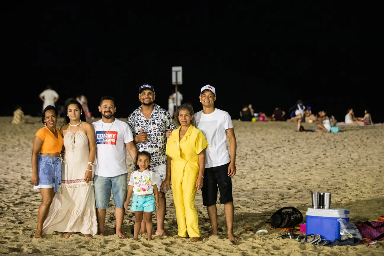 Grupos familiares se organizam na faixa de areia onde seria festa oficial em período sem pandemia