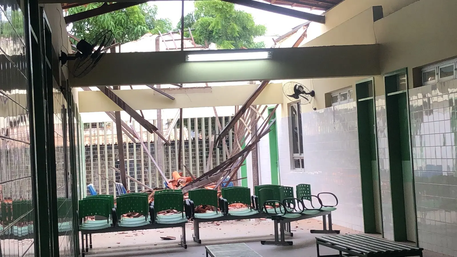 telhado e linhas de madeira caídas sobre cadeiras do posto