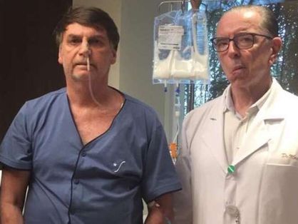bolsonaro com orupa hospitalar ao lado do médico Antônio Luiz Macedo