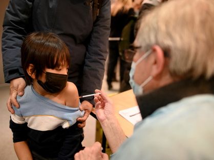 Criança recebe dose da vacina durante visita do Ministro da Saúde da França, Olivier Veran, em centro de vacinação contra Covid-19, em Paris