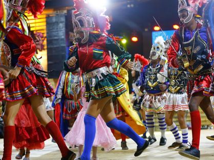 Grupo de pessoas dançando com vestes tradicionais de reisado popular, festividade do Dia de Reis