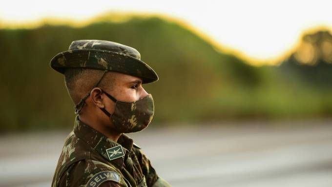 militar do exército de perfil, com uma máscara em estampa igual à farda