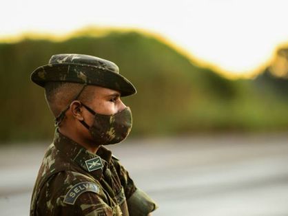 militar do exército de perfil, com uma máscara em estampa igual à farda