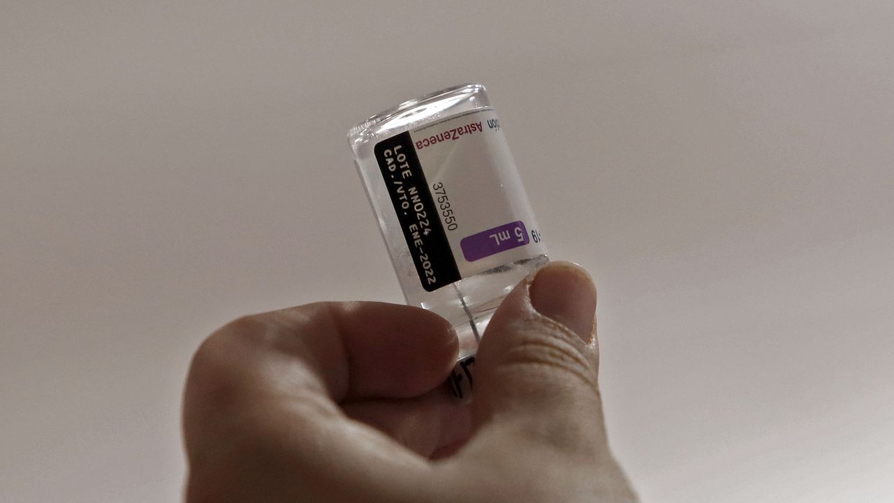 Mão segura frasco de vacina contra a Covid da AstraZeneca