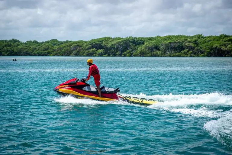 A imagem mostra um bombeiro em uma moto aquática na água.