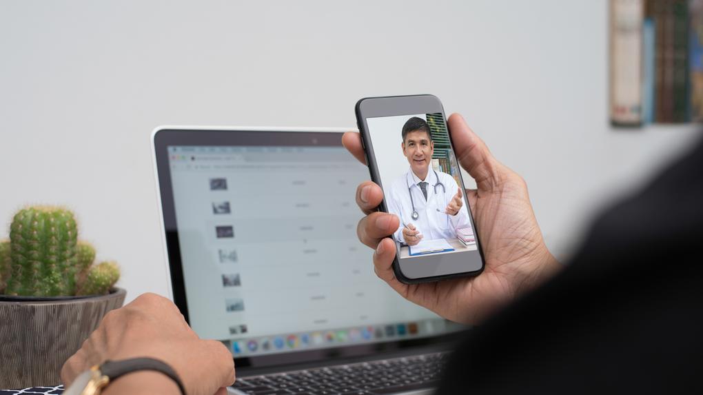 Paciente ouvindo médico amigável via smartphone móvel em casa