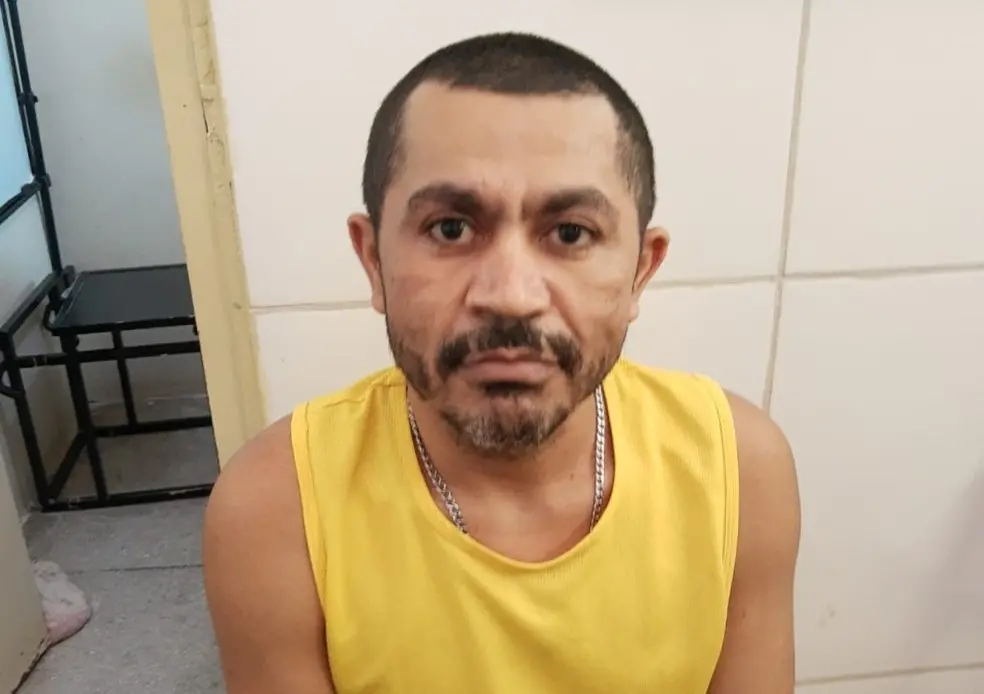 suspeito de cometer o crime vestindo regata amarela e olhando para a câmera