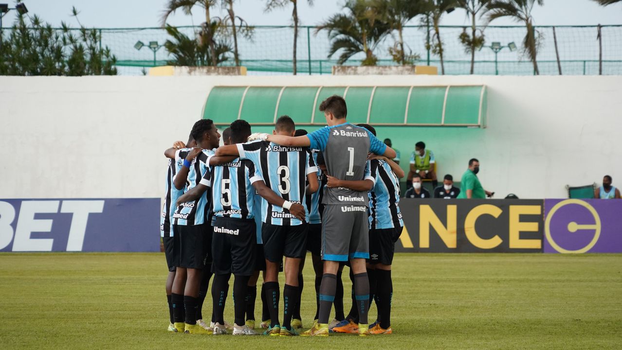 Atletas do Grêmio reunidos em uma roda no gramado antes de mais uma partida pela Copa São Paulo de Futebol Júnior