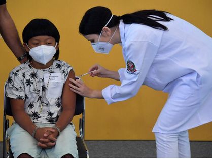 Criança indígena brasileira sendo vacinada contra a Covid-19