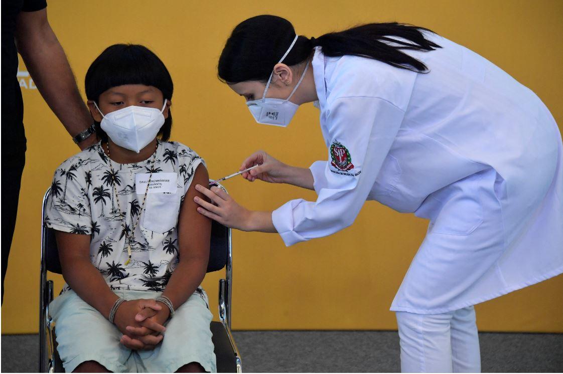Criança indígena brasileira sendo vacinada contra a Covid-19