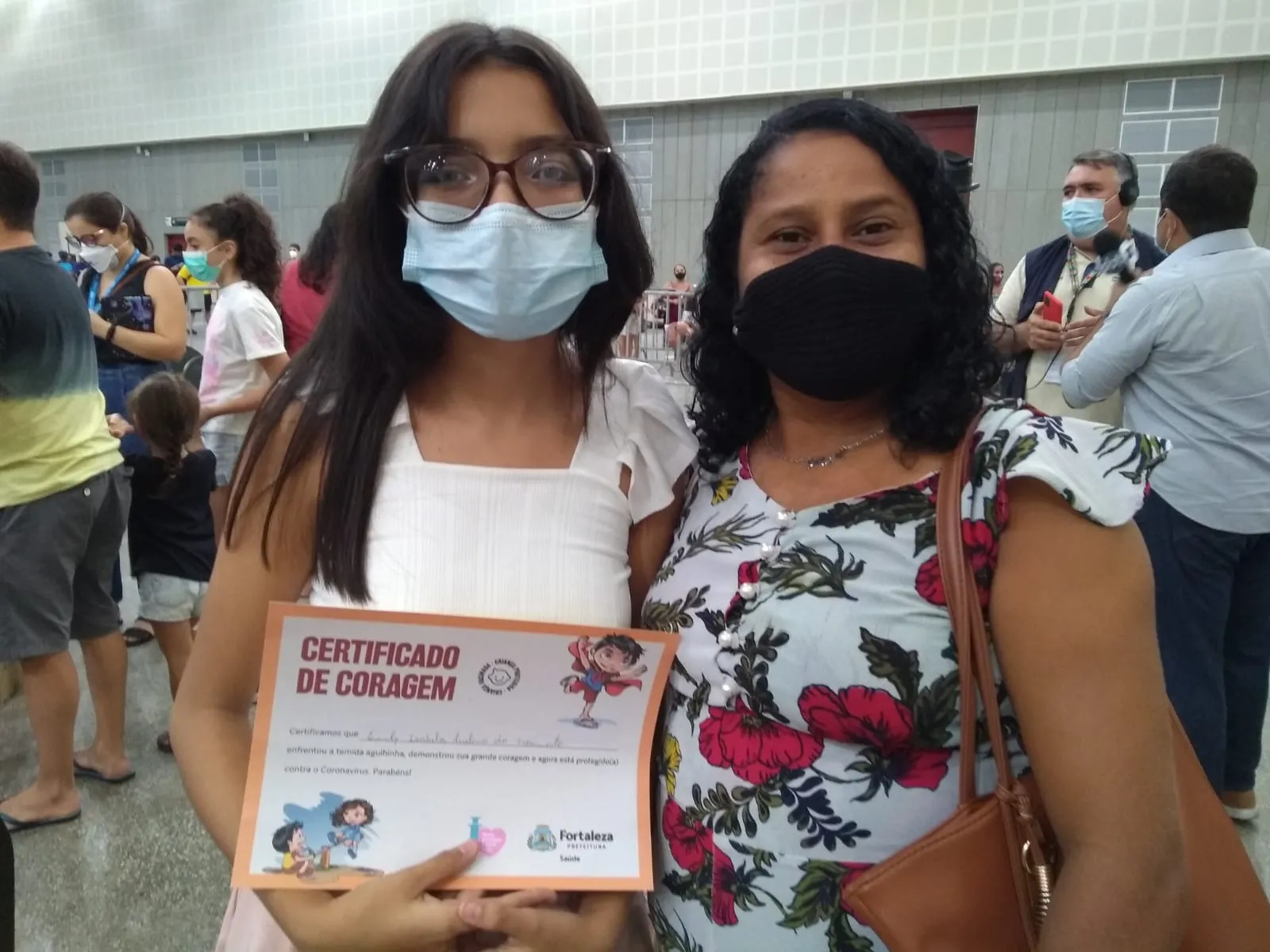Mãe e filham relatam felicidade com a vacina infantil quase um ano após o início da imunização de adultos no Estado