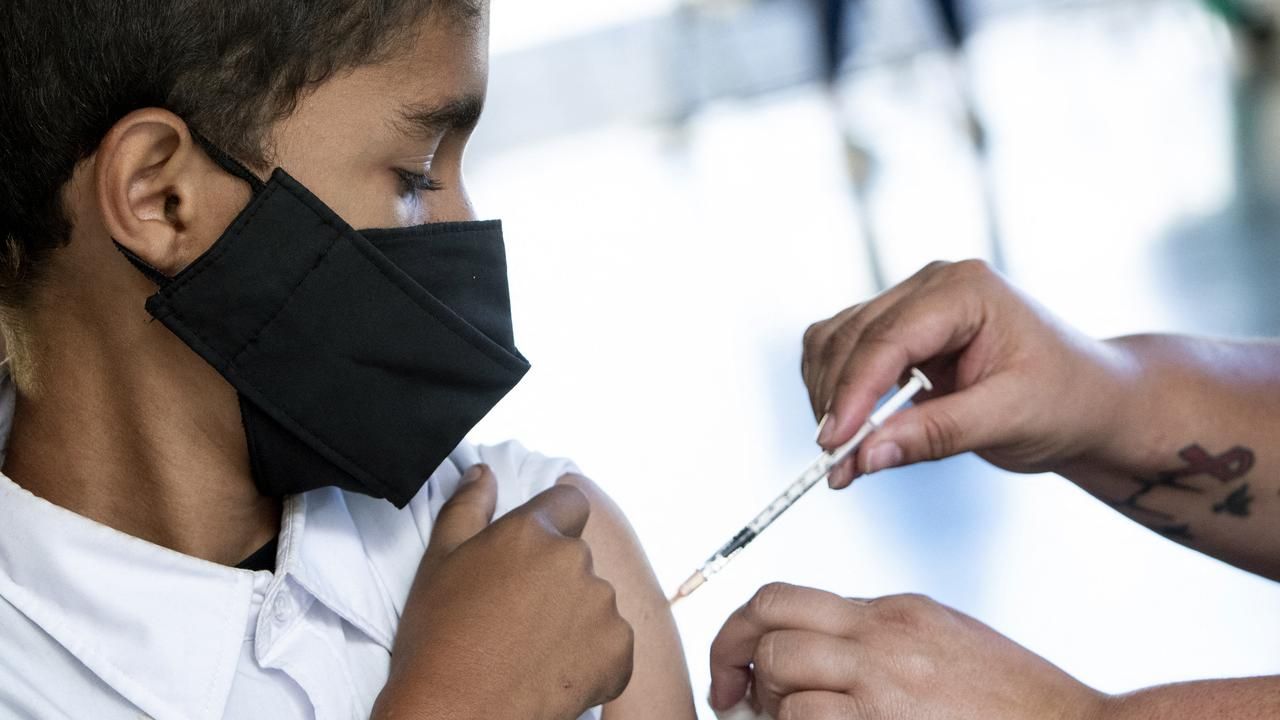 Criança levanta manga da camisa para receber vacina contra a Covid-19.