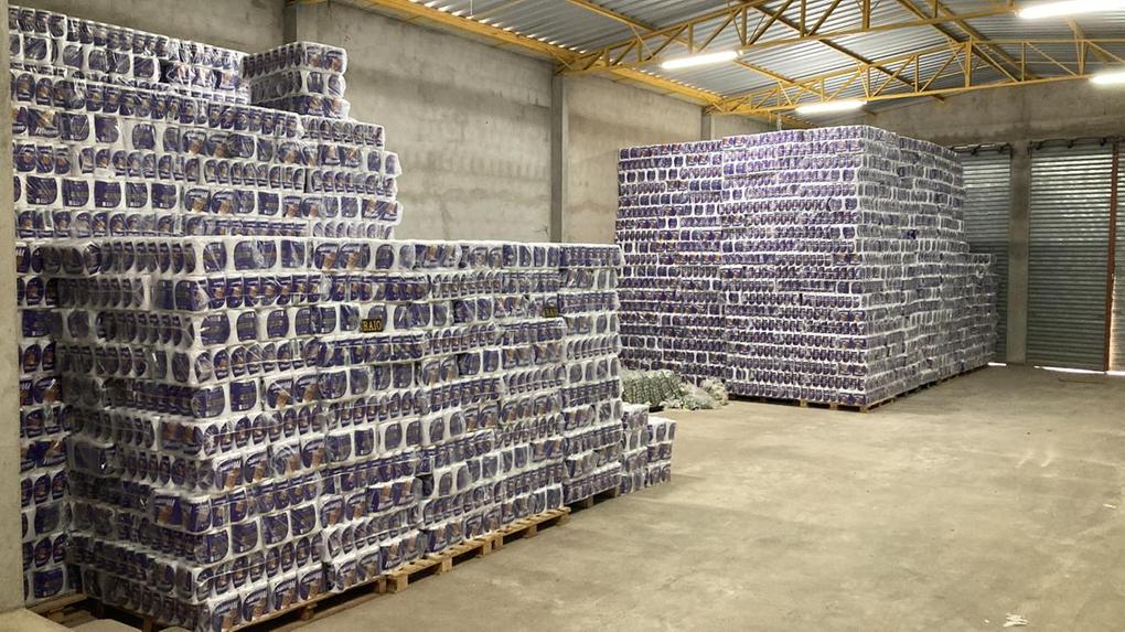 Cerca de 2,4 mil fardos de papel higiênico armazenados num galpão.