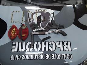 armas e munições apreendidas pela Polícia disposta no capô de uma viatura do BPChoque