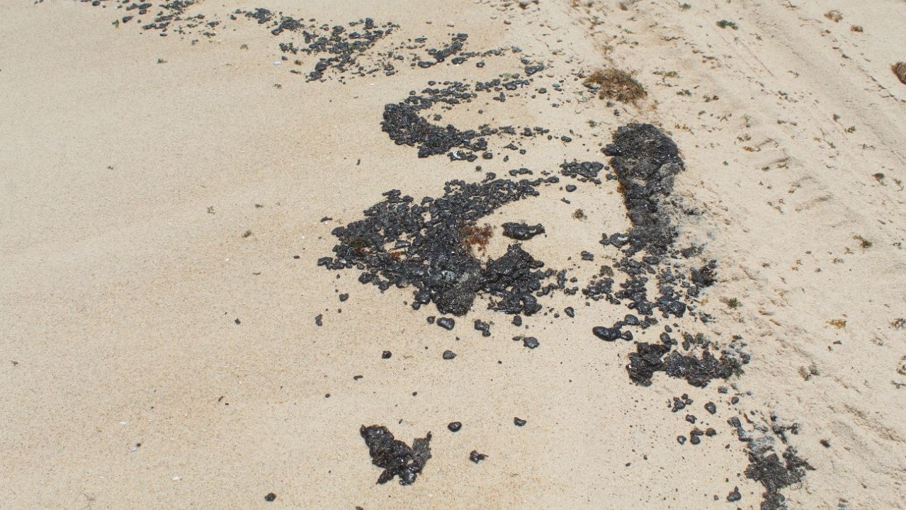 vários pedaços de piche na areia