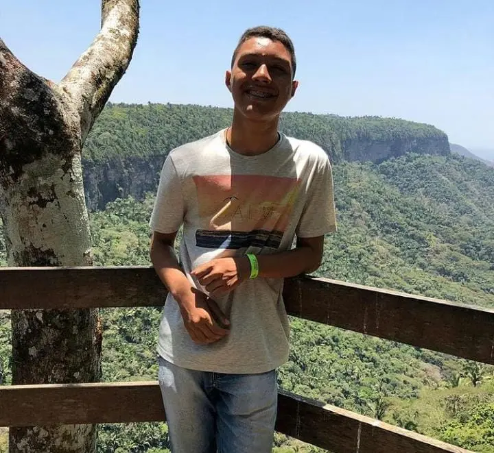 José Luiz escorado a uma cerca, com a paisagem verde de Ubajara ao fundo