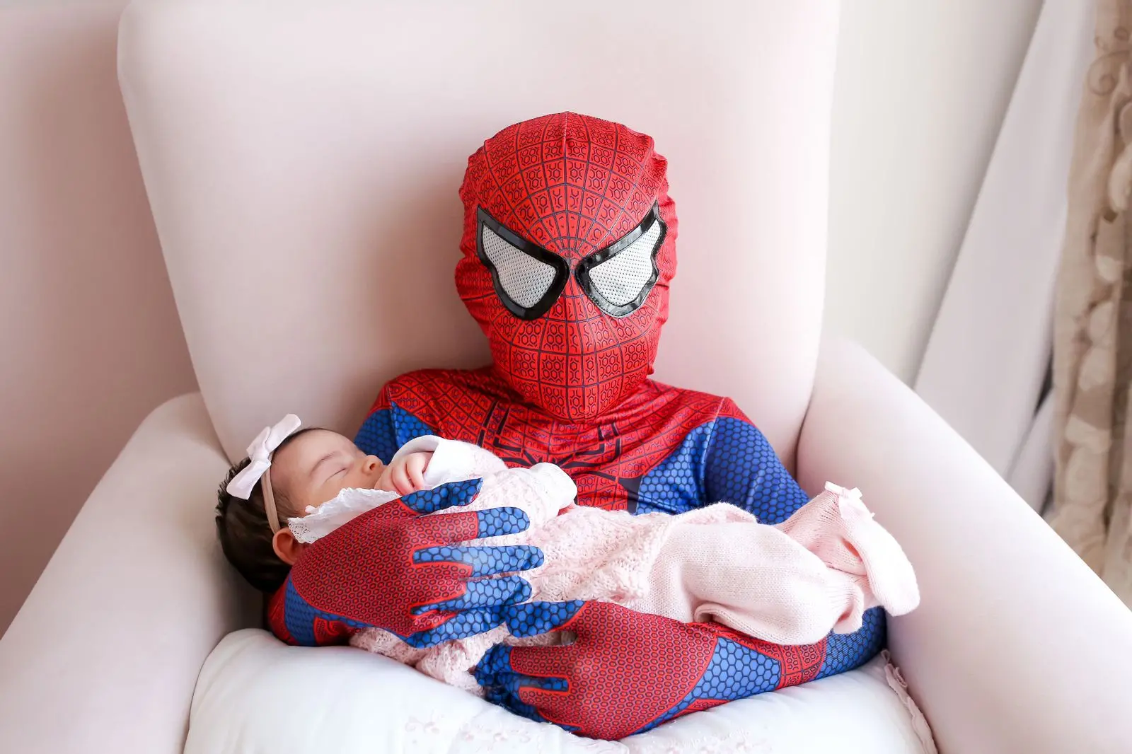 um dos meninos segurando a irmã com o corpo coberto pela fantasia