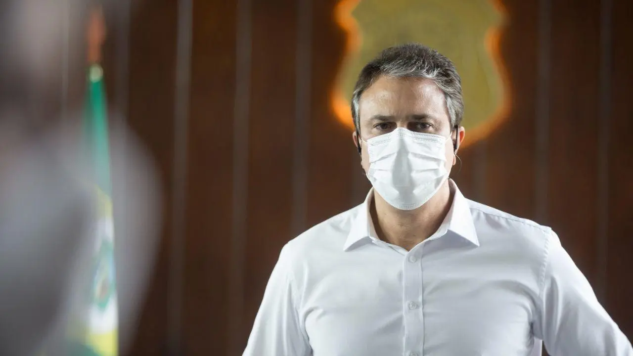 O governador Camilo Santana está de camisa social branca e de máscara branca contra a Covid-19.
