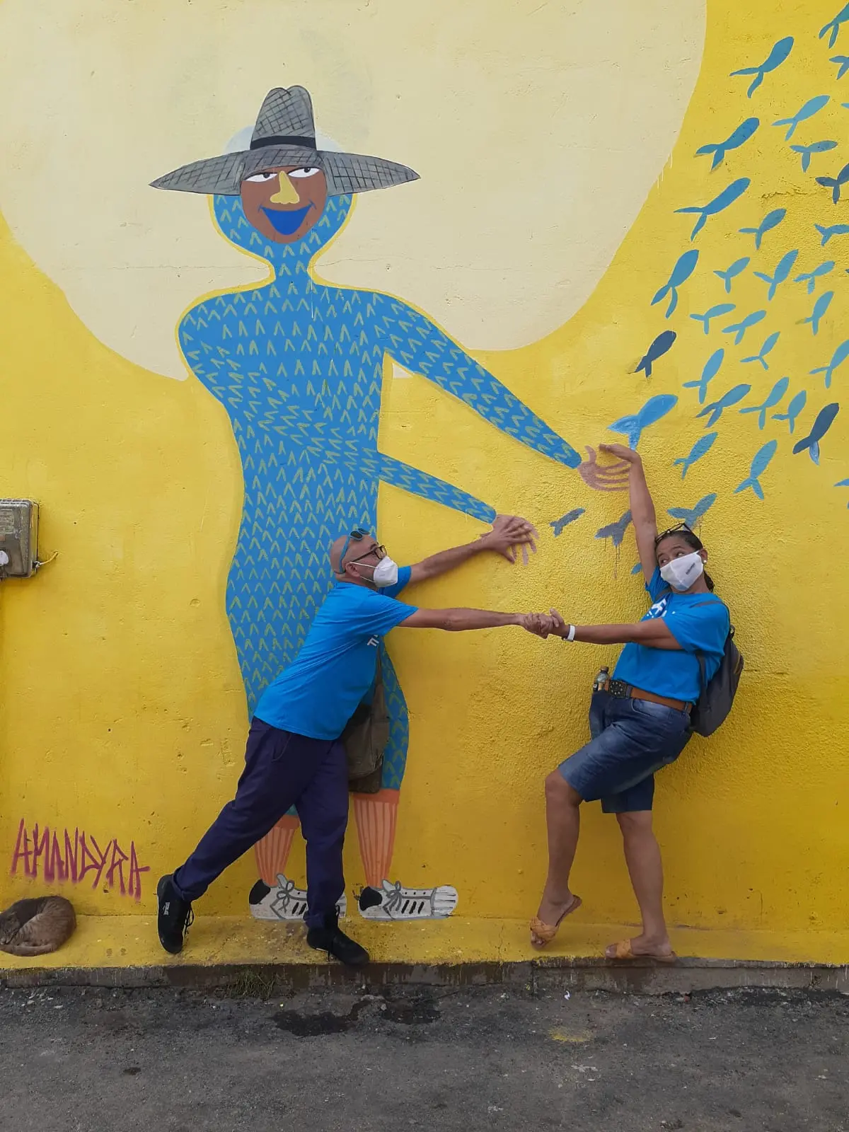 Serginho e Beta interagem com grafite na parede do Poço da Draga