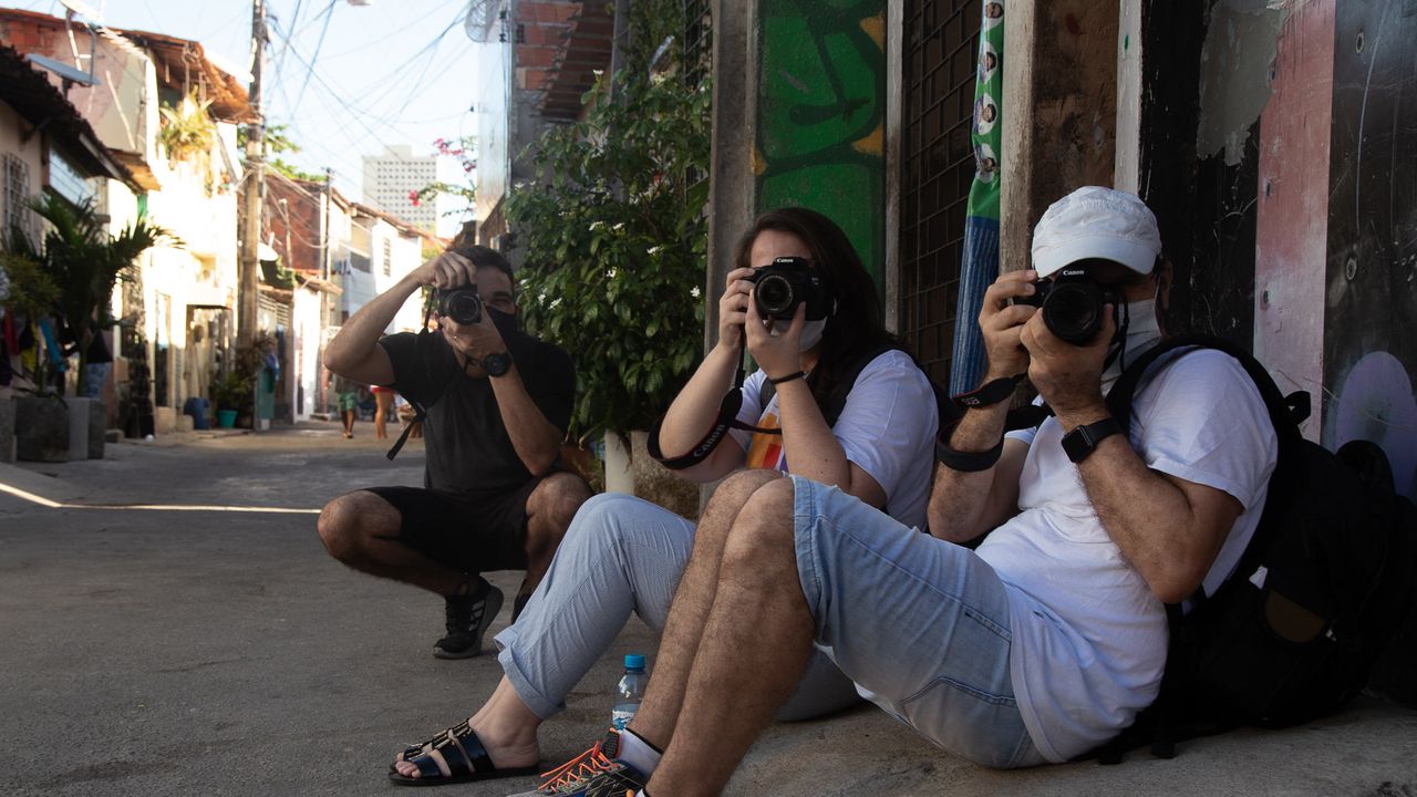 Jovens fotógrafos apontam suas câmeras para a foto