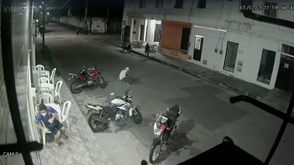 reprodução de imagem de câmera de segurança mostra homem caído na rua após disparo de tiro