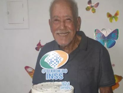 Andrelino Vieira da Silva segura bolo de aniversário com frase 