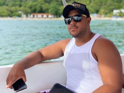 Cantor Samuel Santos segurando celular em passeio de barco
