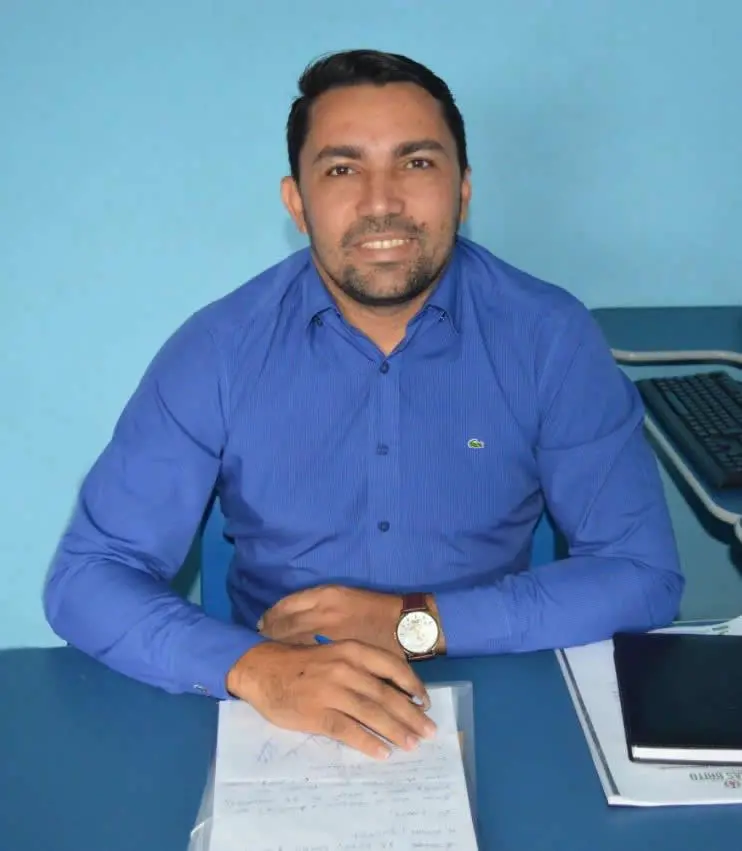 O secretário Roberval Gonçalves de Araújo em seu gabinete na prefeitura de Farias Brito. Está sorrindo e usando uma camisa azul.